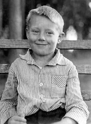 Photo d'enfance : Bertold Hummel, âgé d'environ quatre ans, assis sur un banc à l'extérieur, 1929.