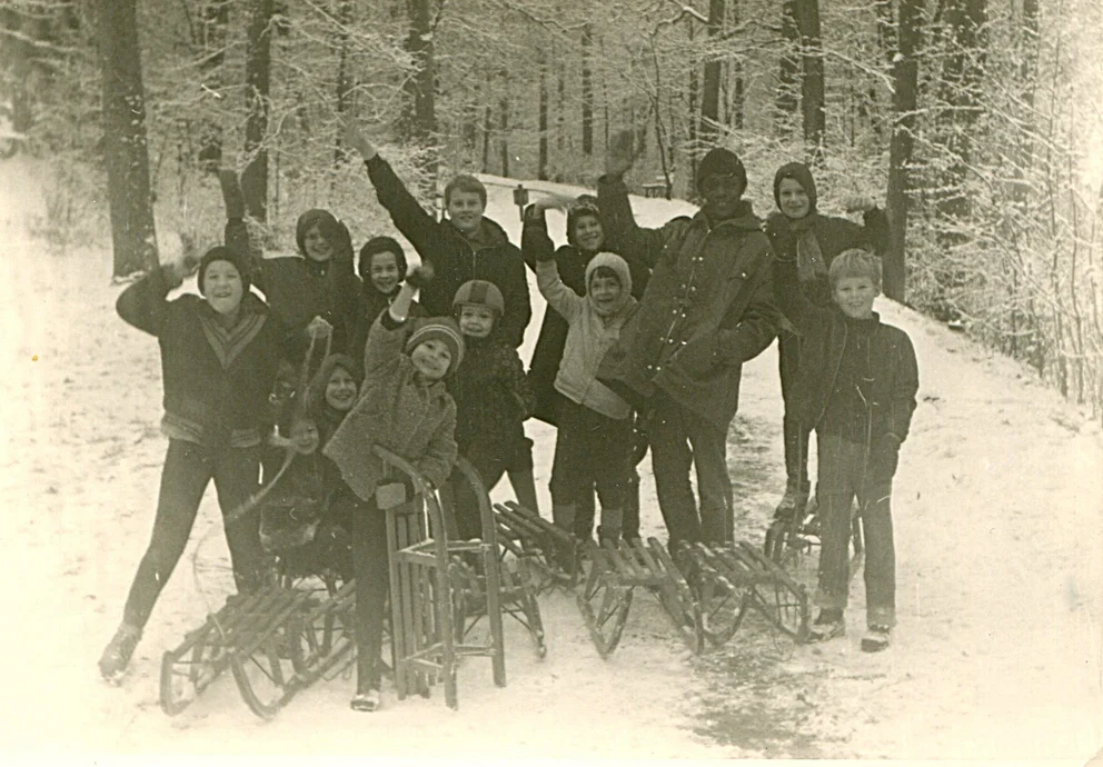 Marion Brown avec les enfants de la famille Hummel et d'autres enfants en luge dans la vallée enneigée du Steinbach, à Wurtzbourg, décembre 1968